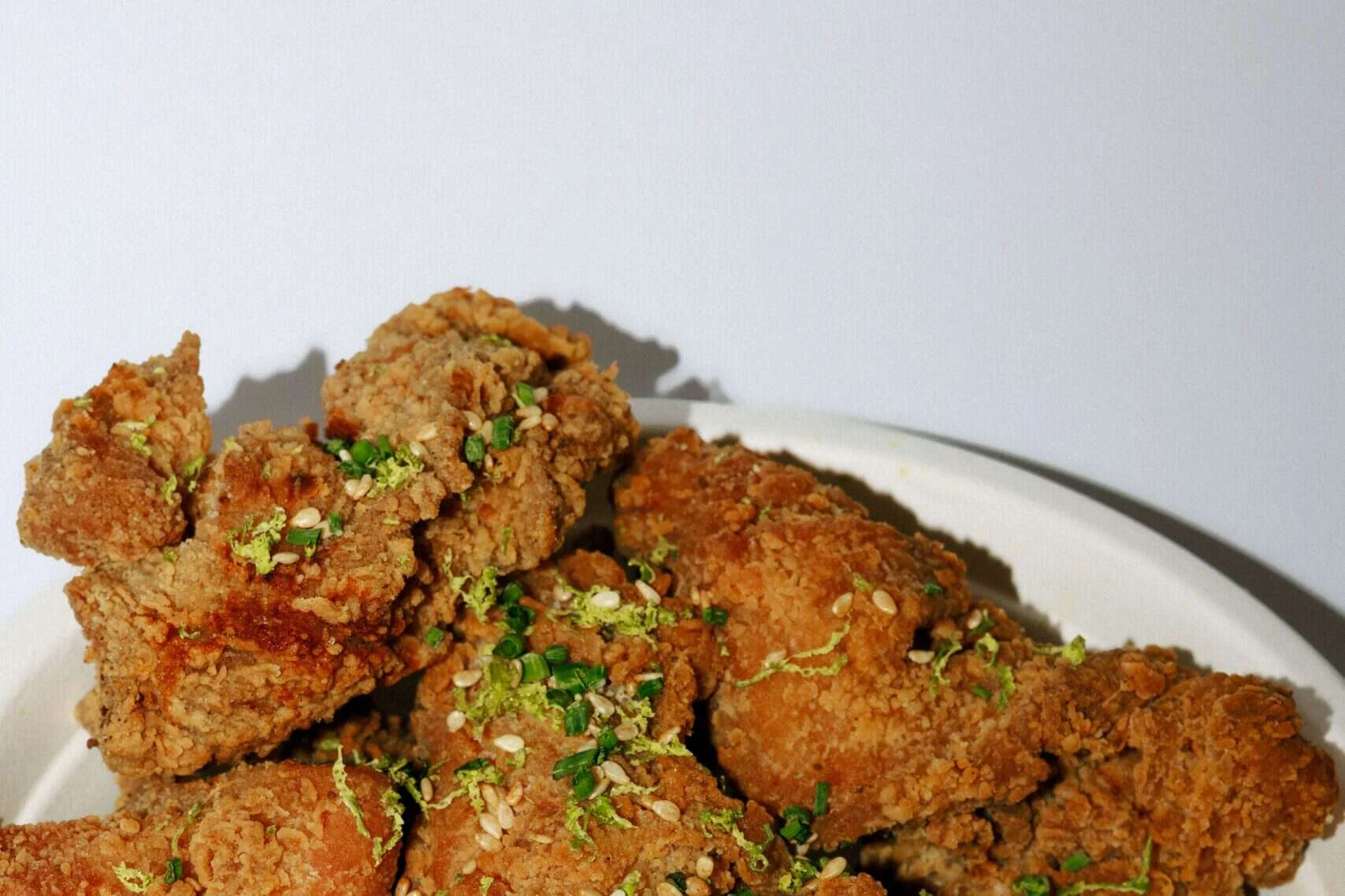 Crispy karaage fried chicken pieces with lime and spring onion, fried fresh to order at Wishbone in Bica, Lisbon